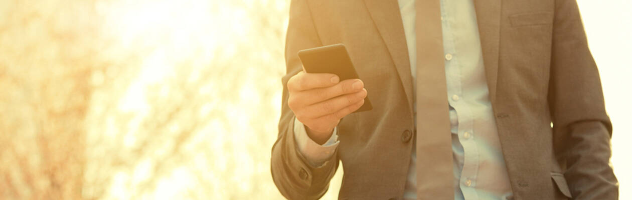 man  in suit holding cell phone